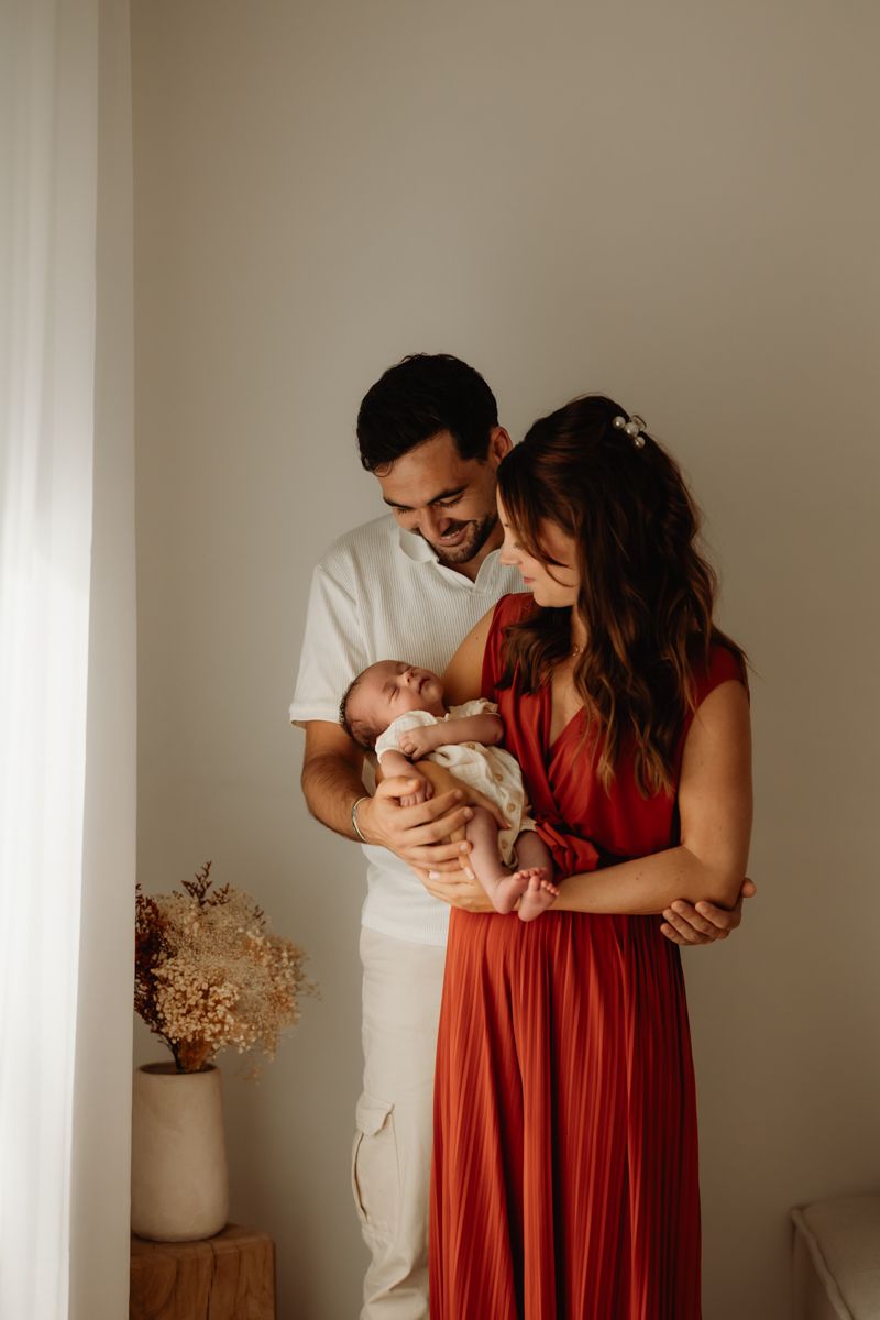 Bébé dans les bras de ses parents pendant un shooting photo à Vannes