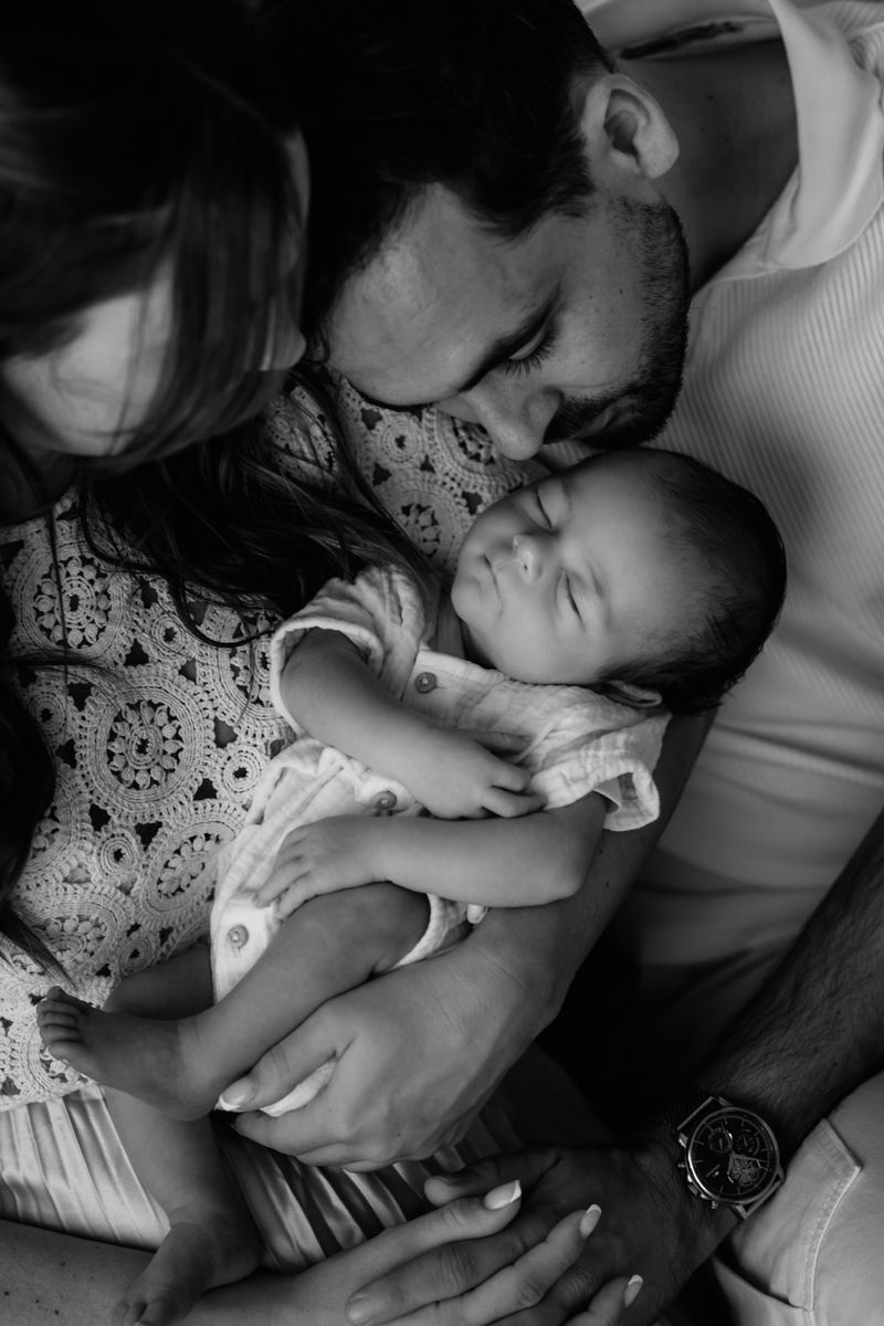 Un bébé dans les bras de ses parents pour une séance photo à Vannes