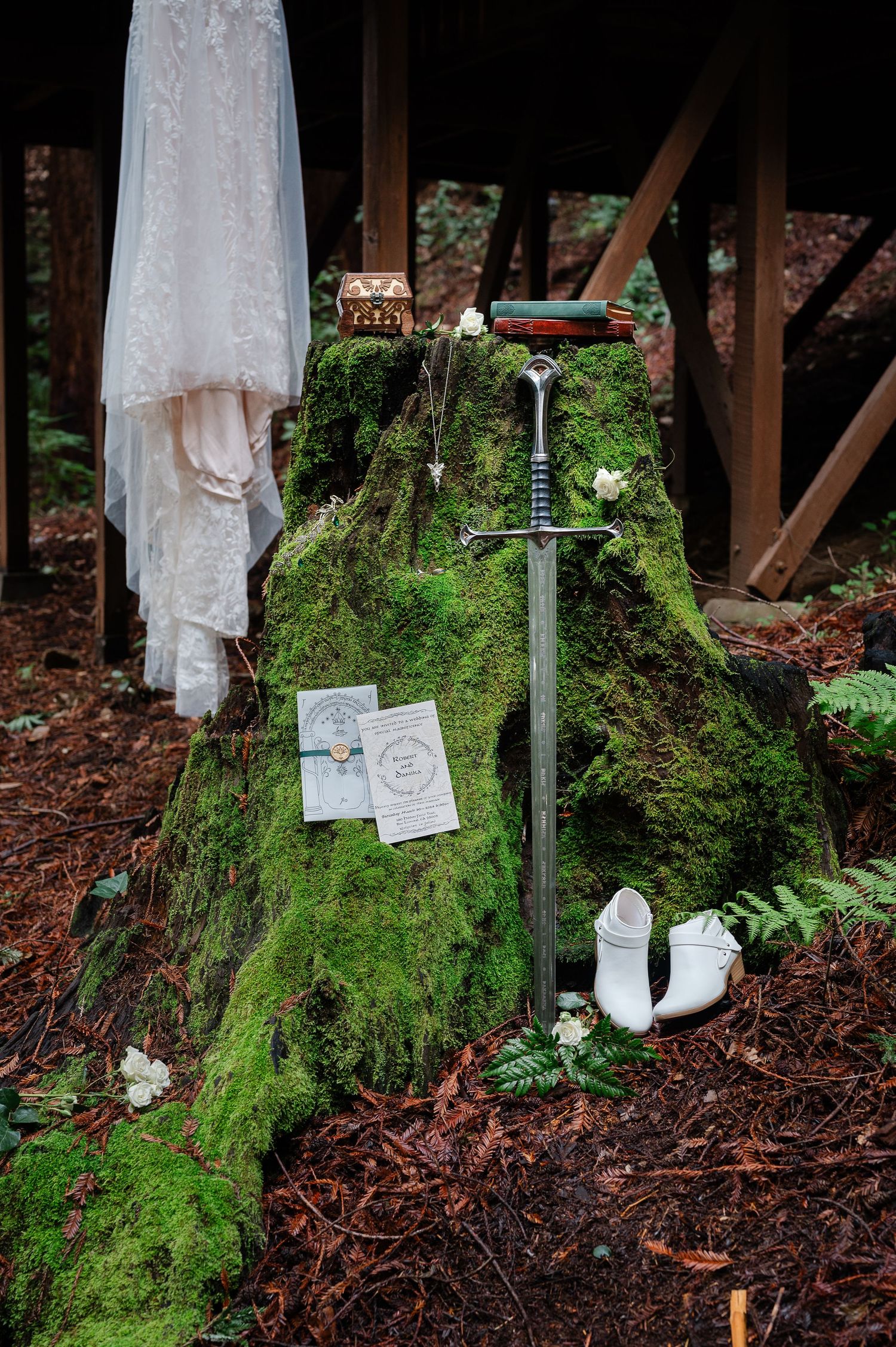 Silver Evenstar pendant necklace displayed against mossy green tree trunk backdrop in ethereal forest setting.