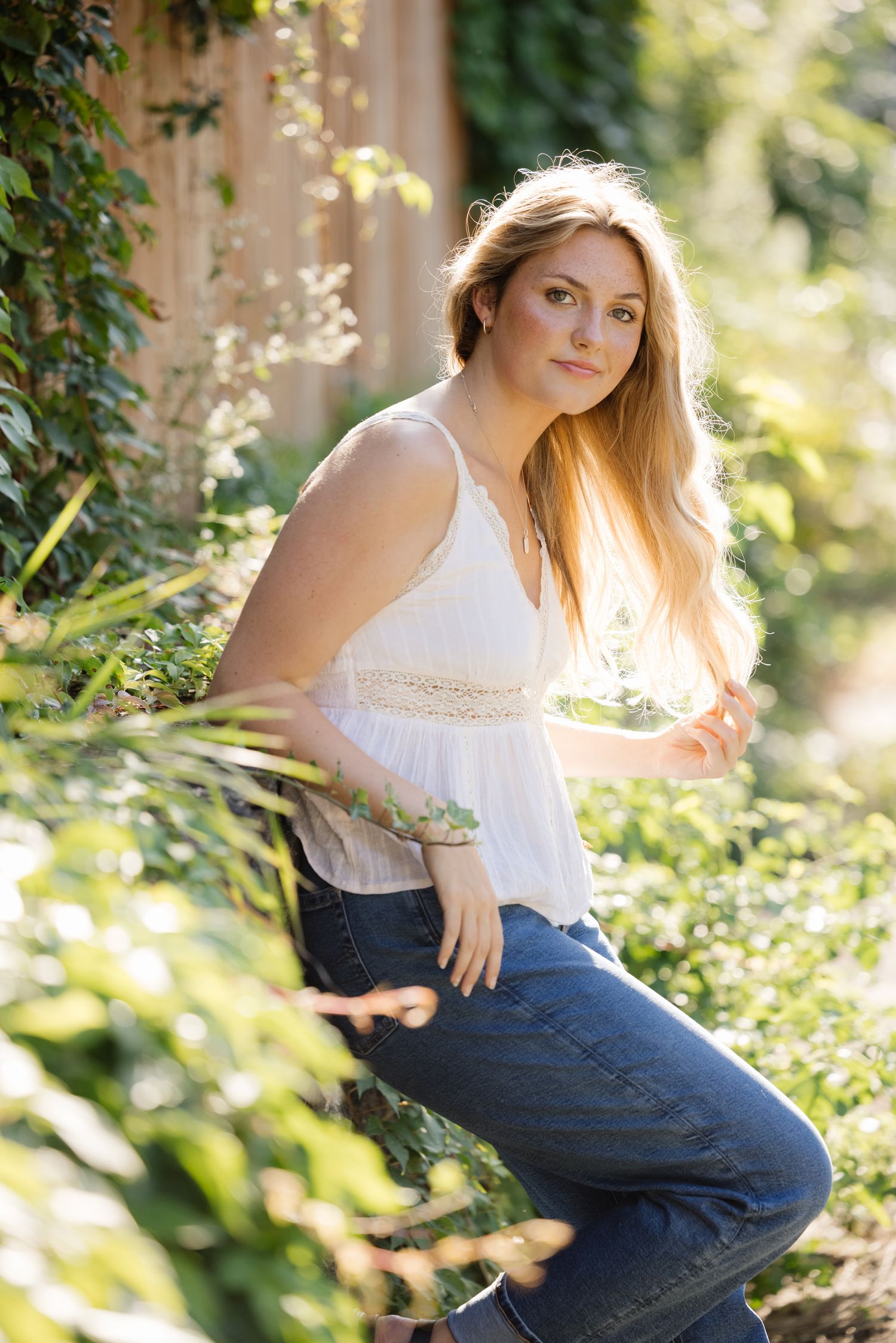 Dreamy summer portrait near flowering plants and stone architecture.