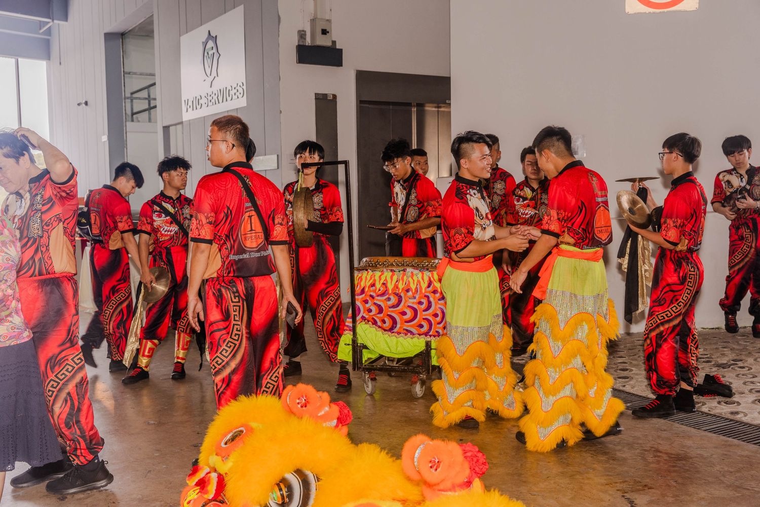 Group performing traditional lion dance in red costumes during a cultural celebration.
