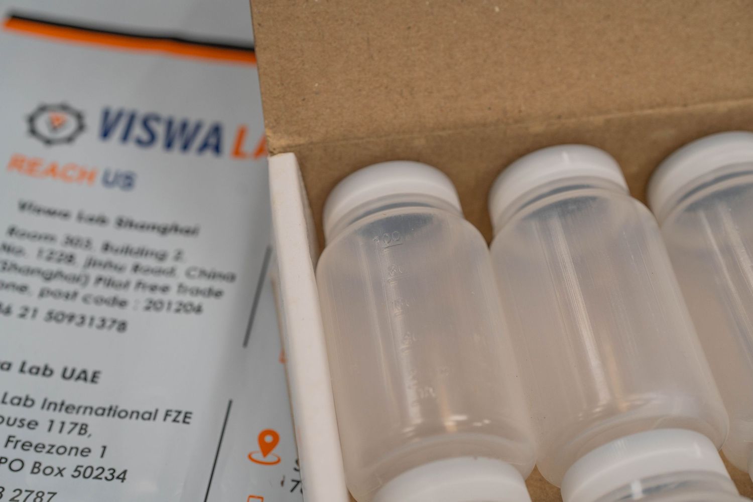 Open shipping box showing Viswa Lab branding and clear bottles inside.