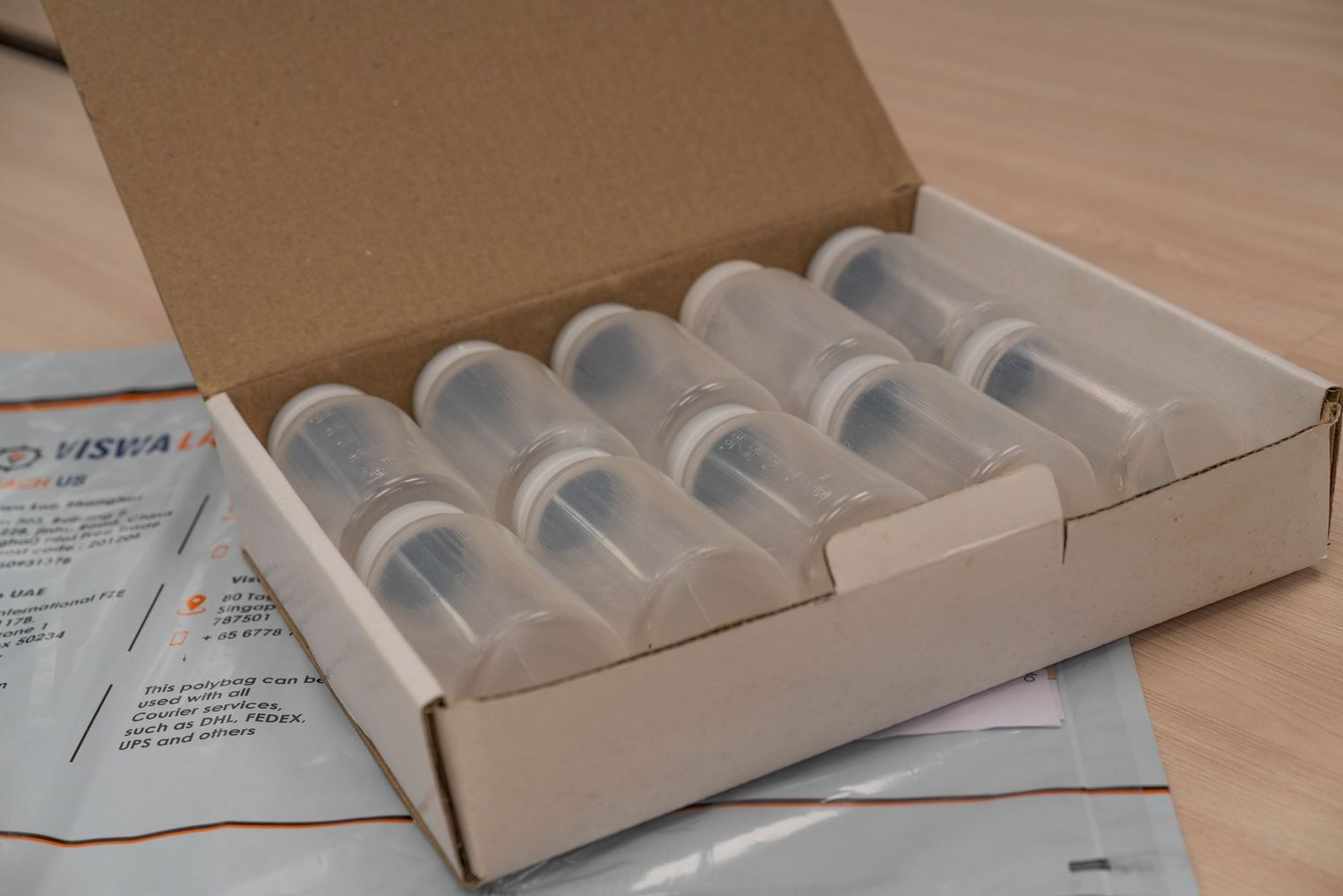 Laboratory vials arranged neatly in protective cardboard packaging.