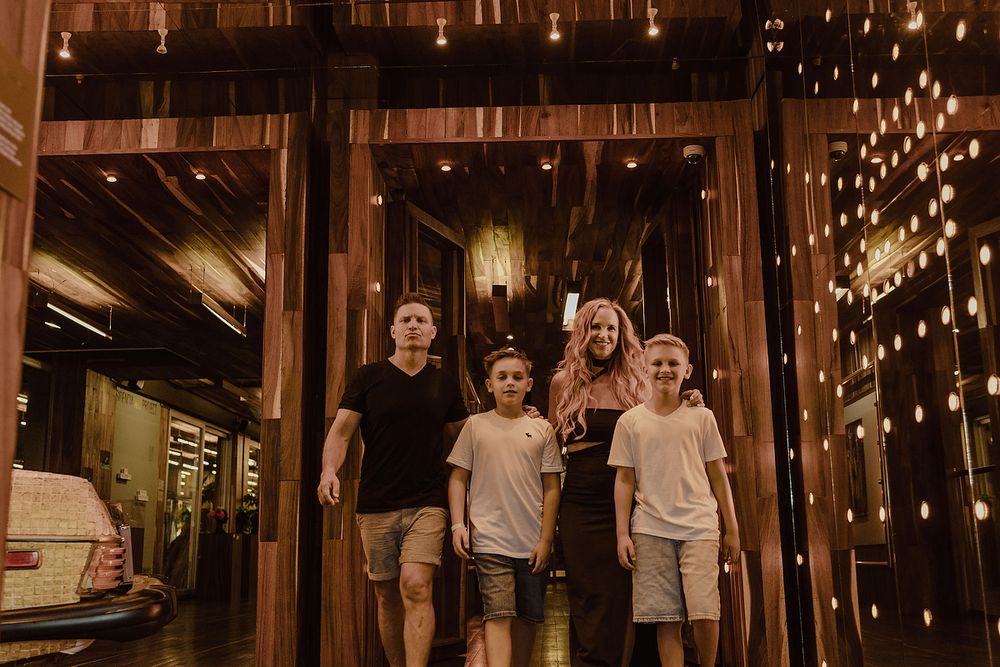 Family standing together at art gallery entrance during editorial family photoshoot in Playa del Carmen.