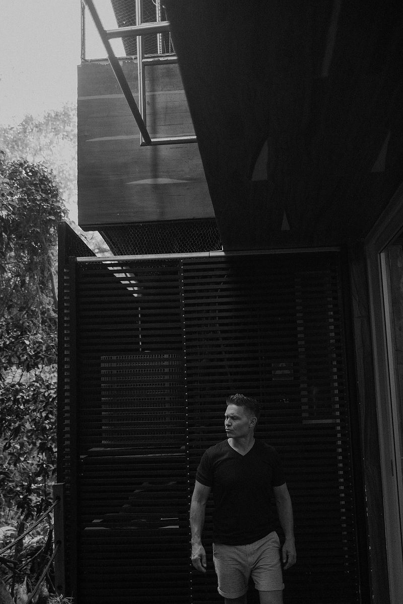 Black and white candid portrait of father walking in modern art space in Playa del Carmen.