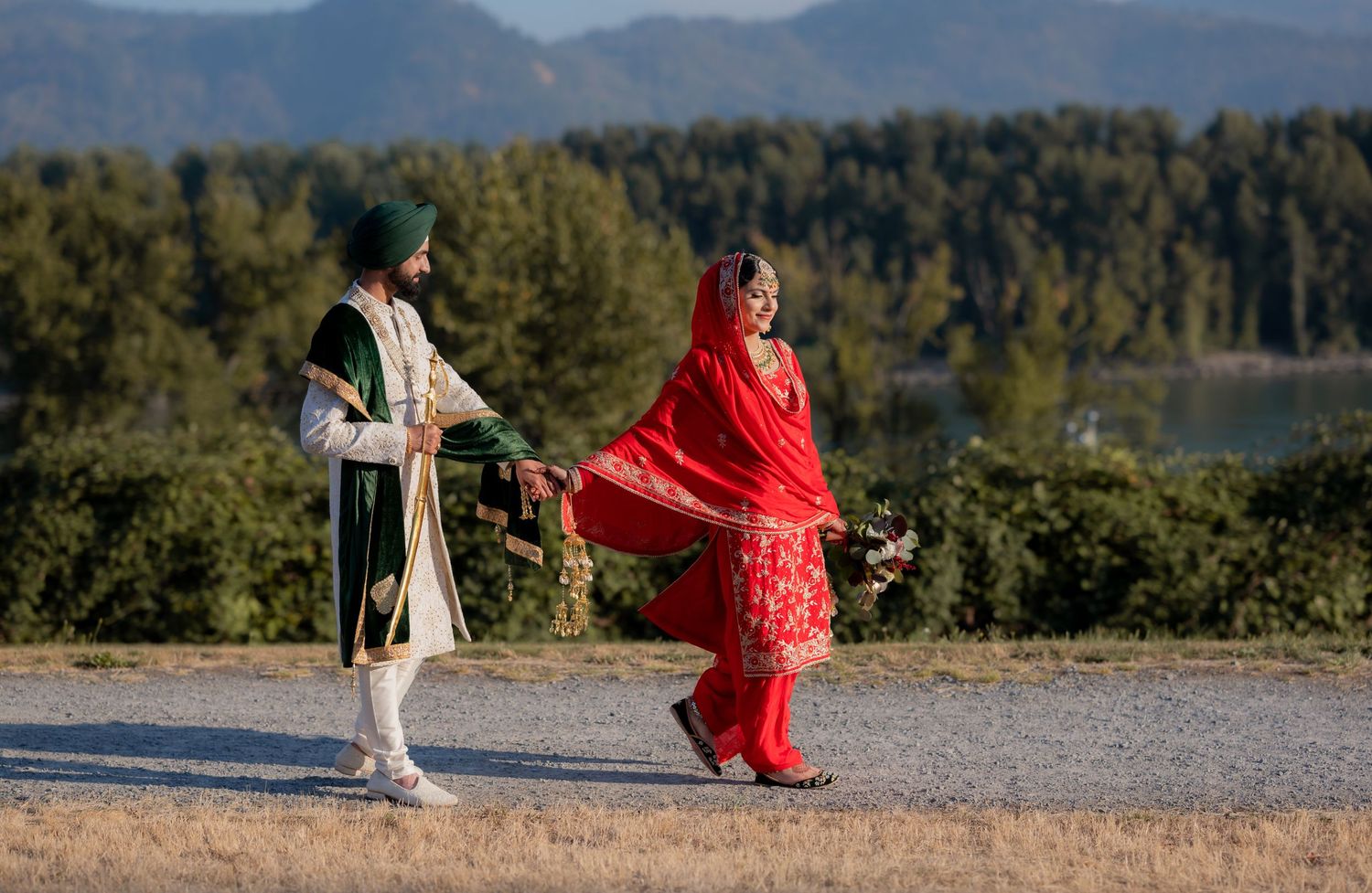 Couple dancing together on scenic mountain overlook with forest backdrop.
