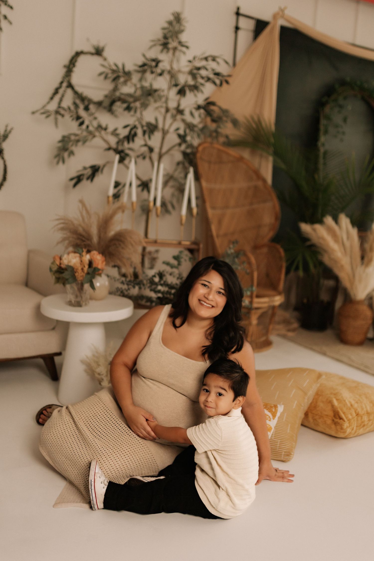 Cozy indoor maternity session with bohemian decor and potted plants.