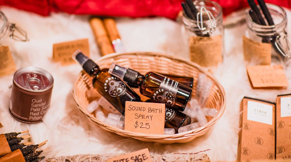 Vintage style display of brown glass bottles and mason jars arranged on a rustic wooden surface with cinnamon sticks.