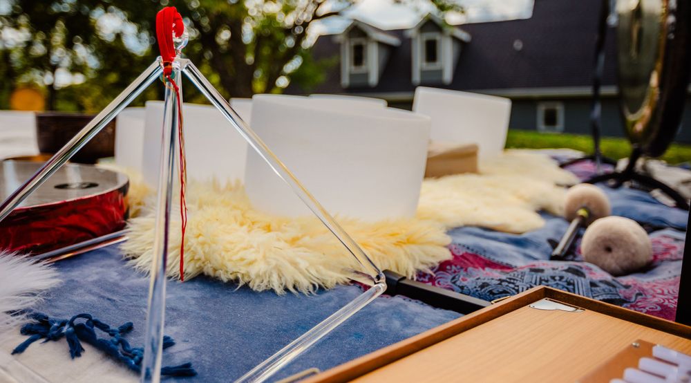 Close-up of craft supplies and tools including yarn and wood sticks arranged on a blue surface outdoors.