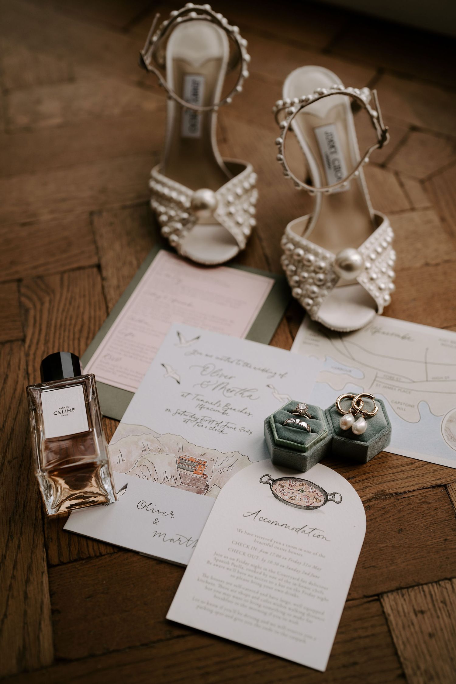 Tunnels Beach wedding venue, bridal jewellery, shoes and perfume laid out on the wedding stationary