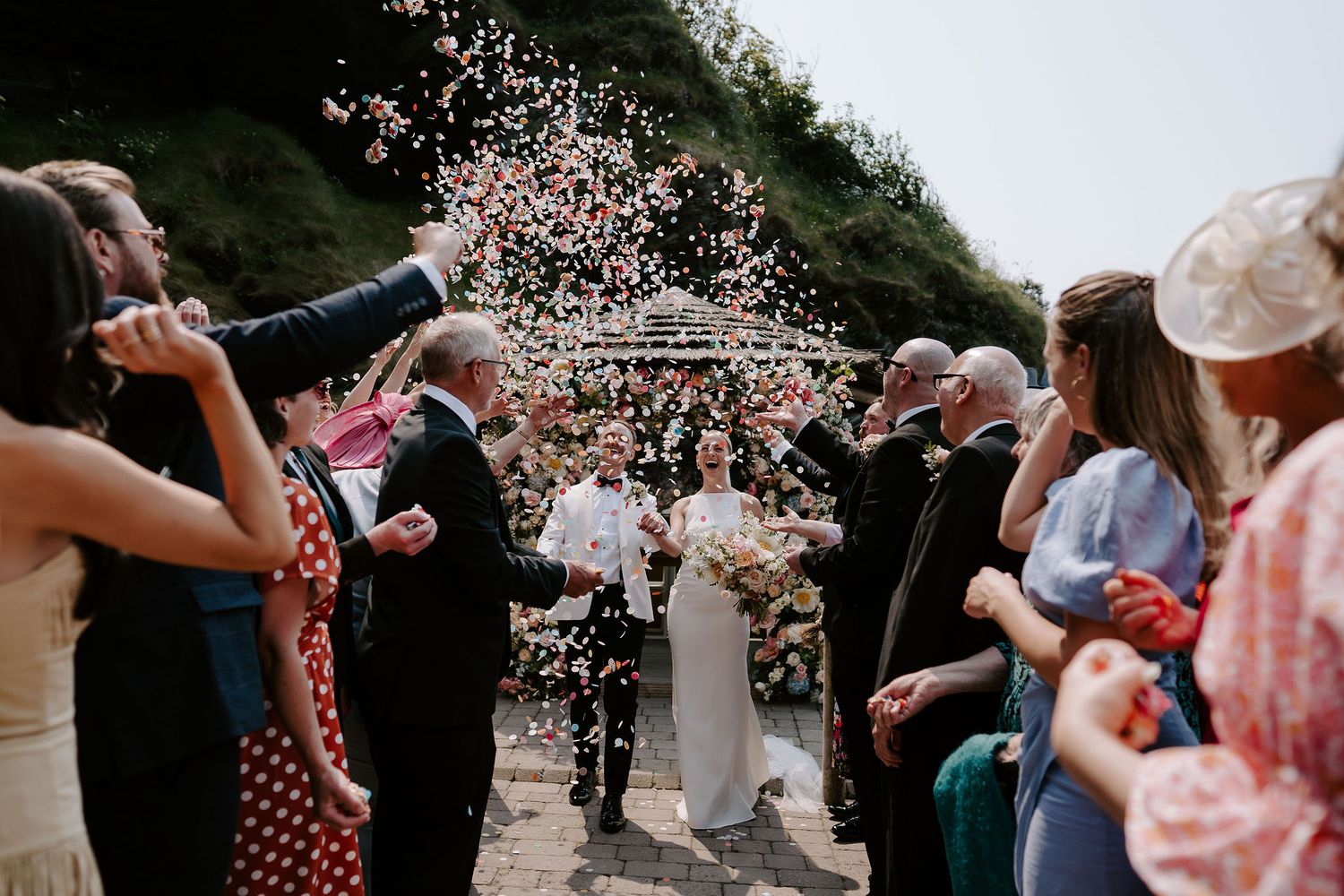 Bride and groom confetti throw at tunnels beach wedding venue in north Devon