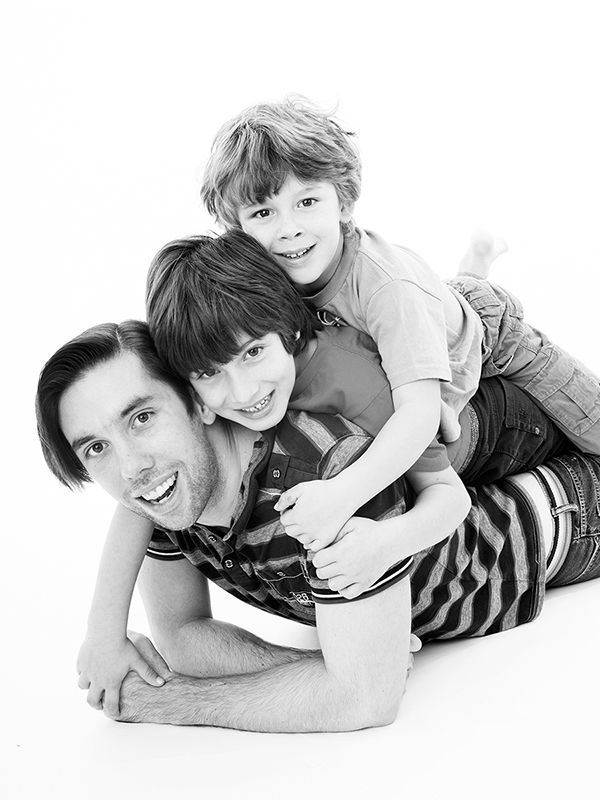 A fun family portrait featuring a man and two boys reclining on the floor, taken by Abigail's Studio in High Wycombe.
