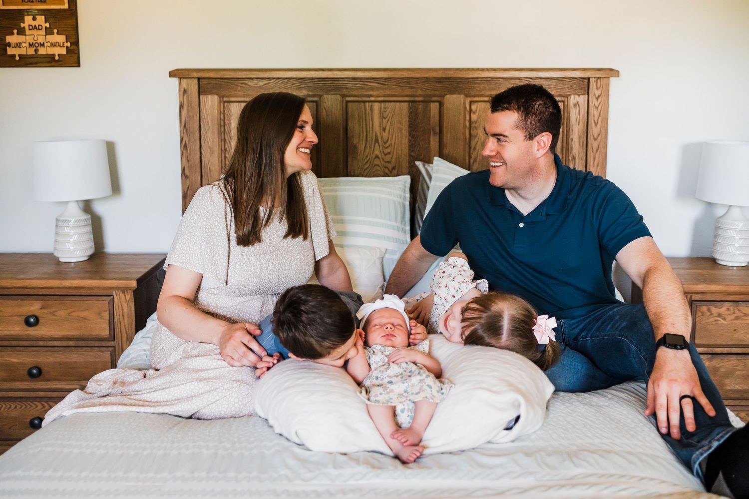 A stylish lifestyle family photography session showing soft, warm moments together on a bed with neutral decor.