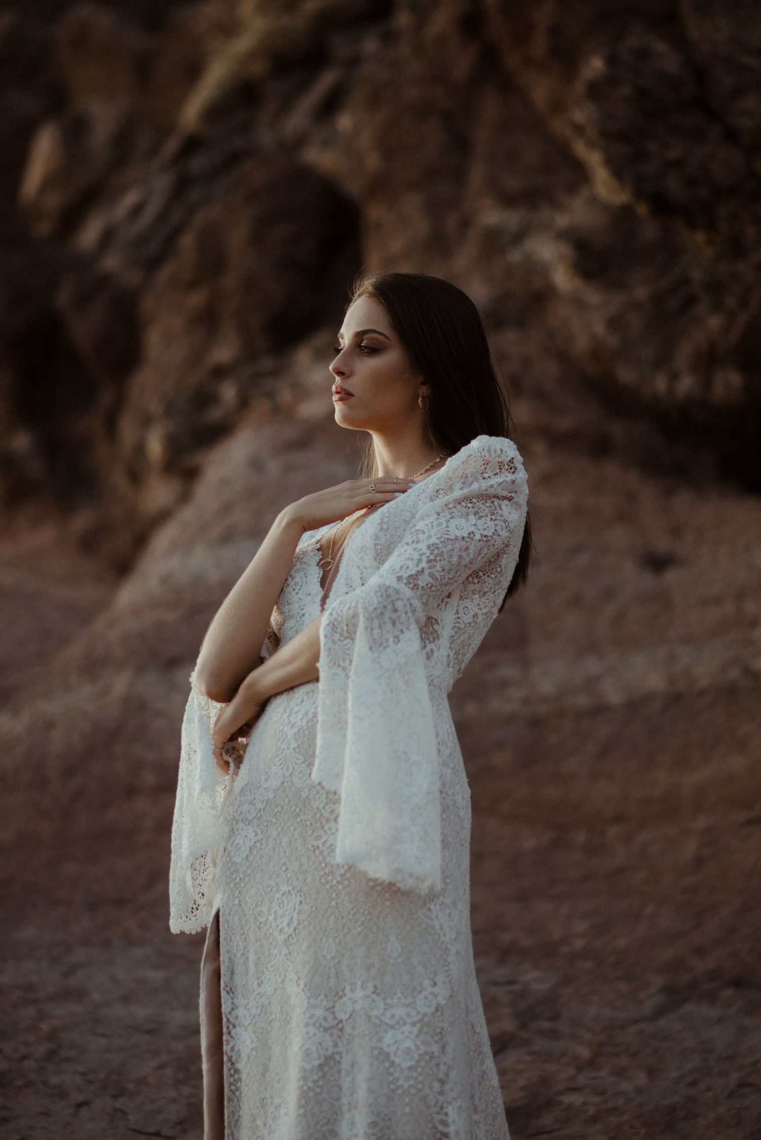 Dreamy portrait in sheer lace dress against desert backdrop at golden hour.
