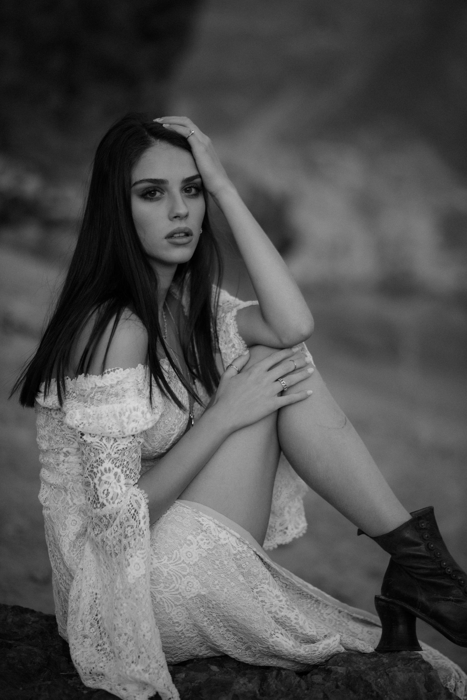 A moody black and white portrait showcasing a lace dress and combat boots.