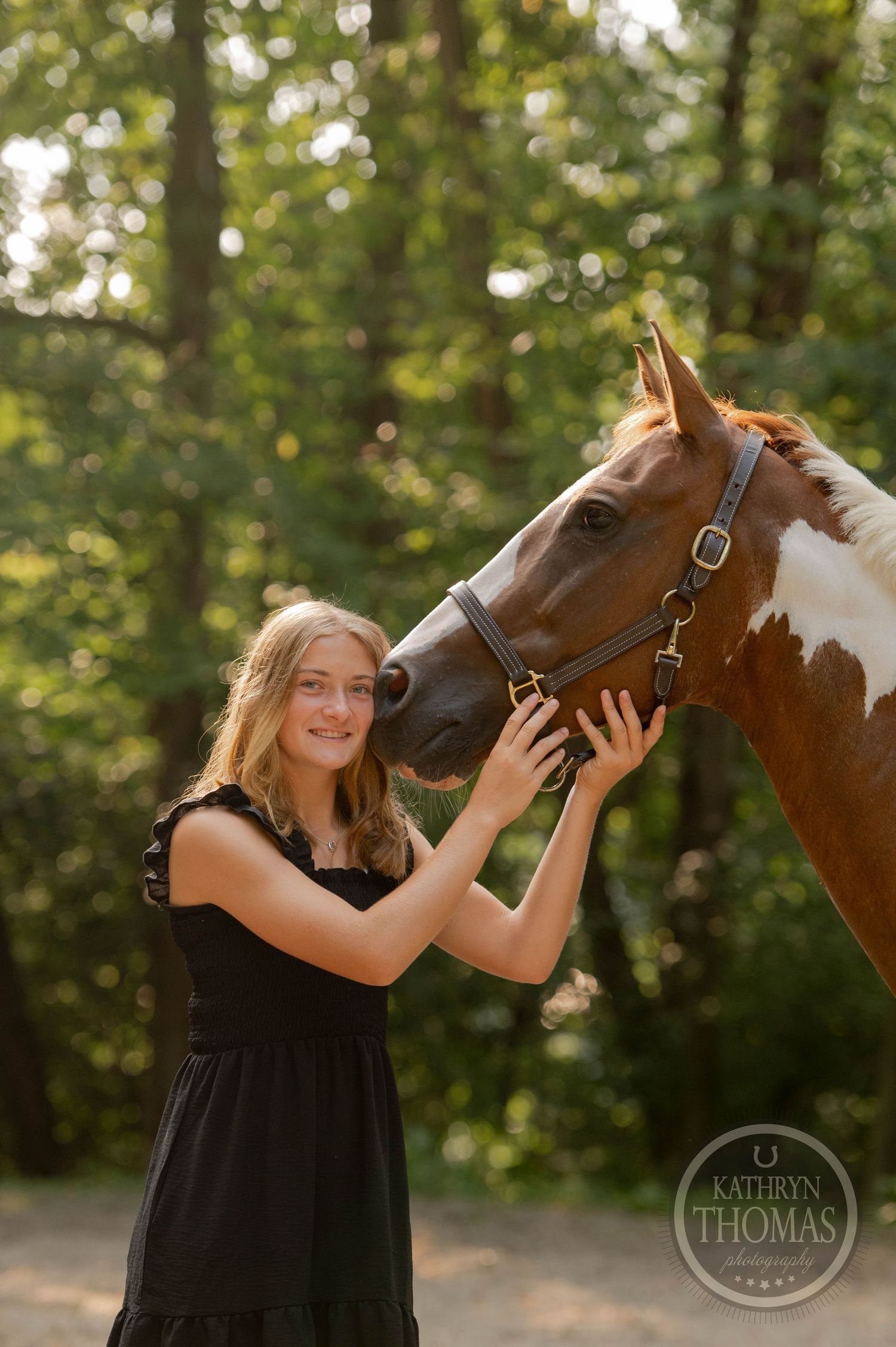 Person in black dress affectionately petting chestnut horse with white markings.