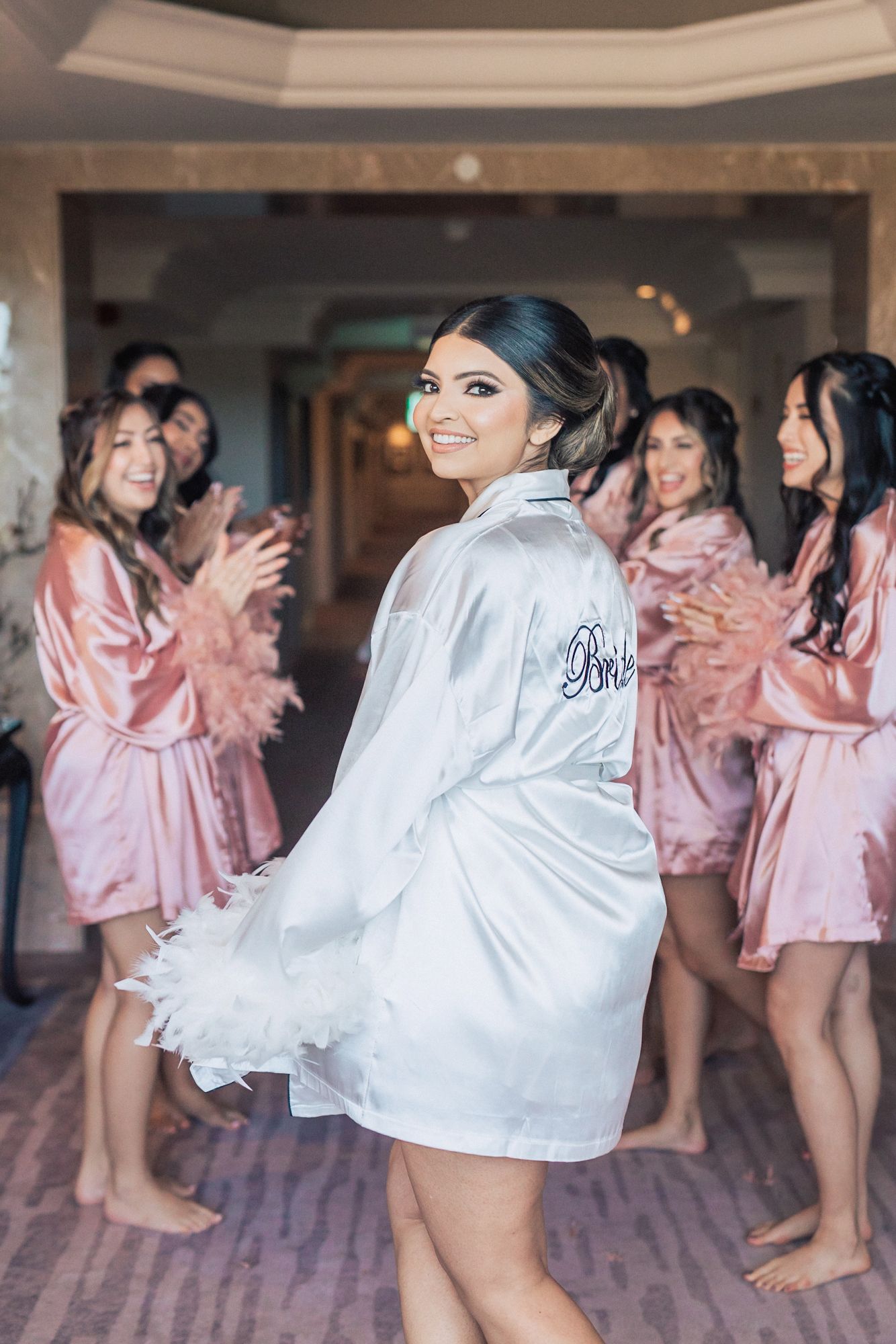 The bride with bridsmaids in pink robes getting ready for her Destination Indian Wedding in Portugal at Penha Longa Resort