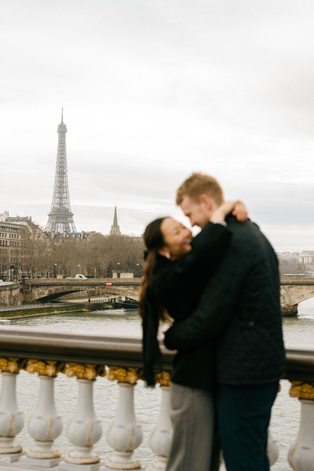 A romantic moment at sunset with the Eiffel Tower and Seine River creating a dreamy Parisian backdrop.