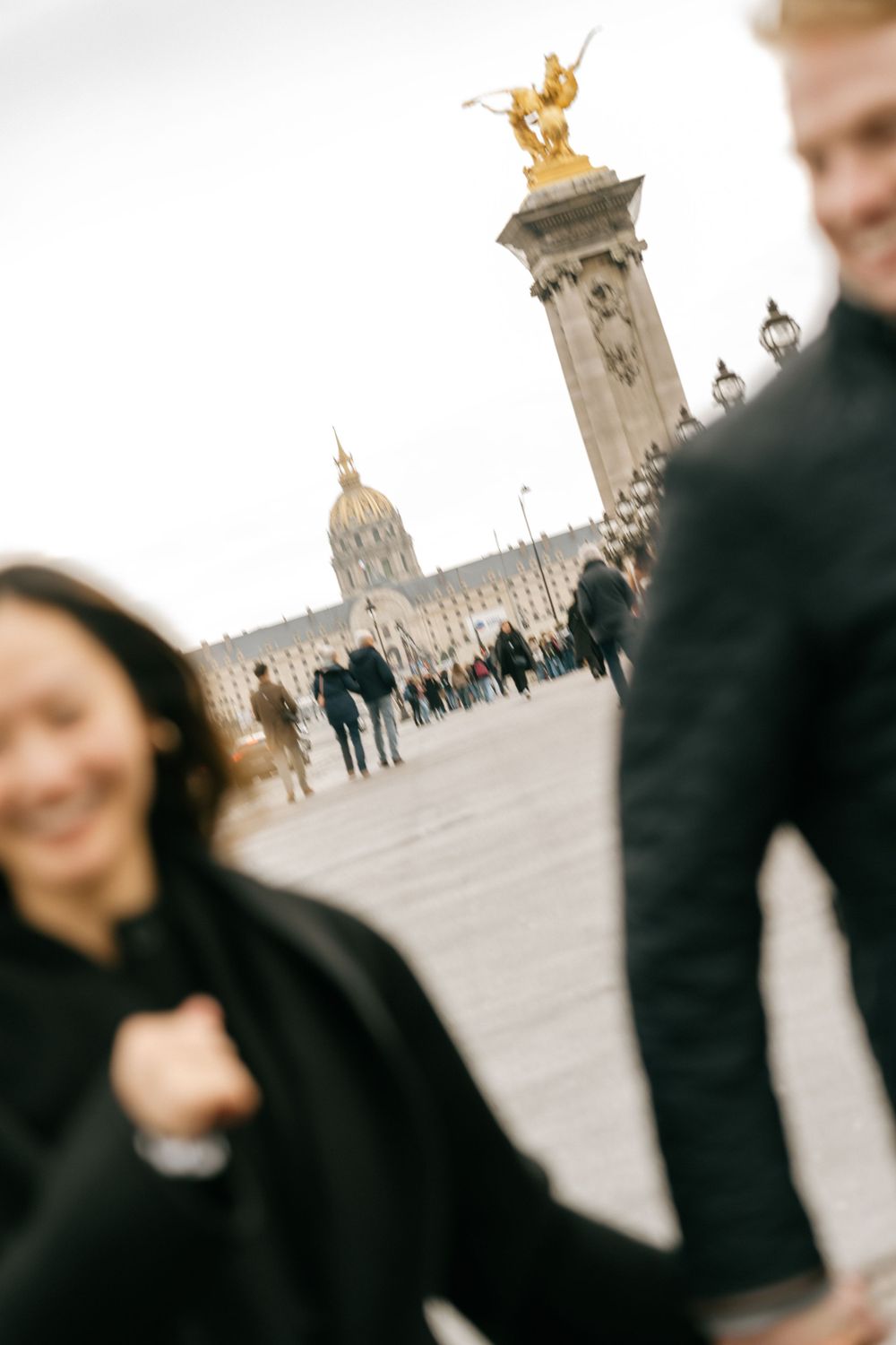 Blurred motion photo of the iconic Pont Alexandre III bridge in Paris with its golden statues and ornate architecture.