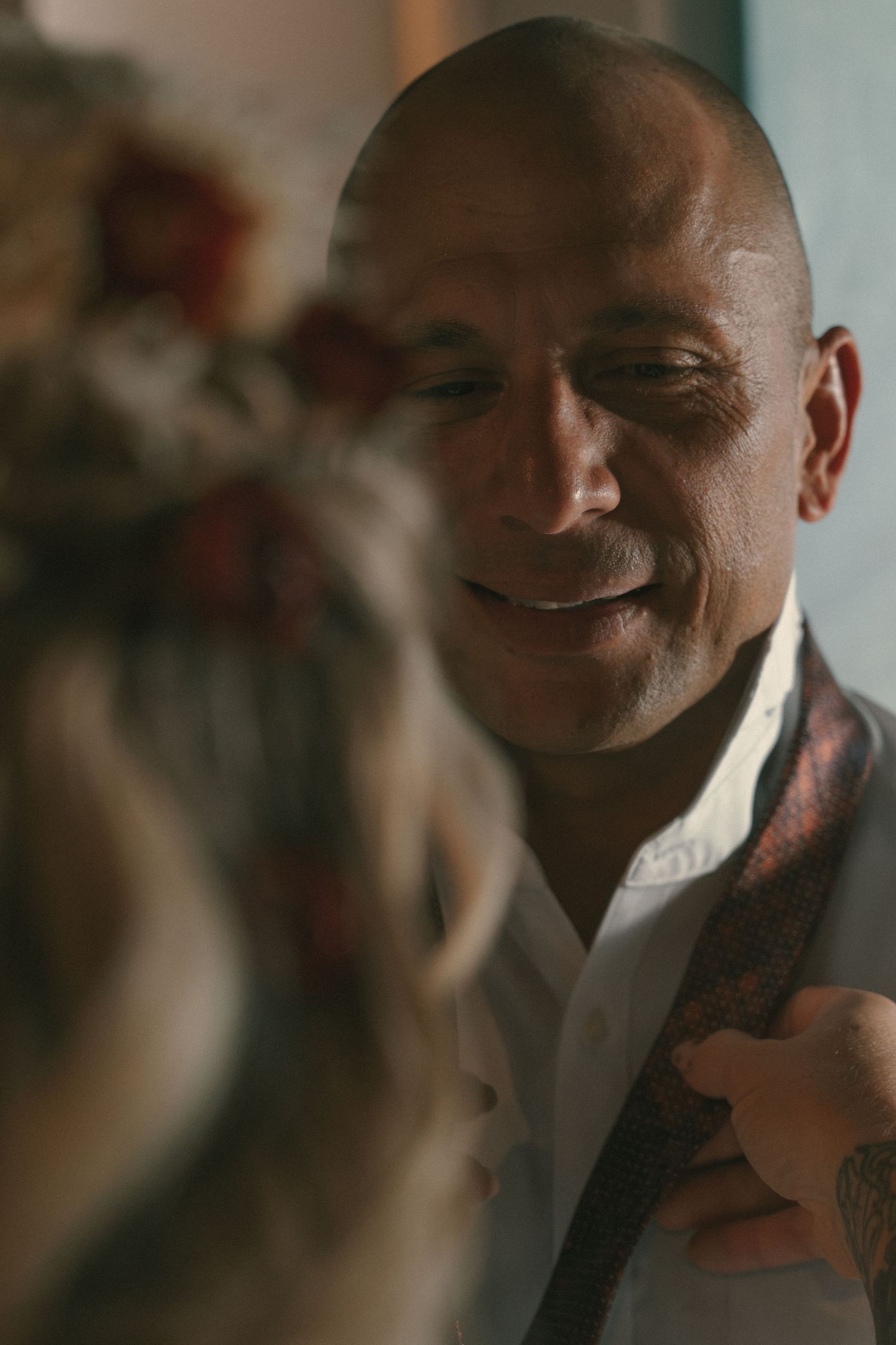 Warm lighting illuminates a person smiling in an intimate portrait.