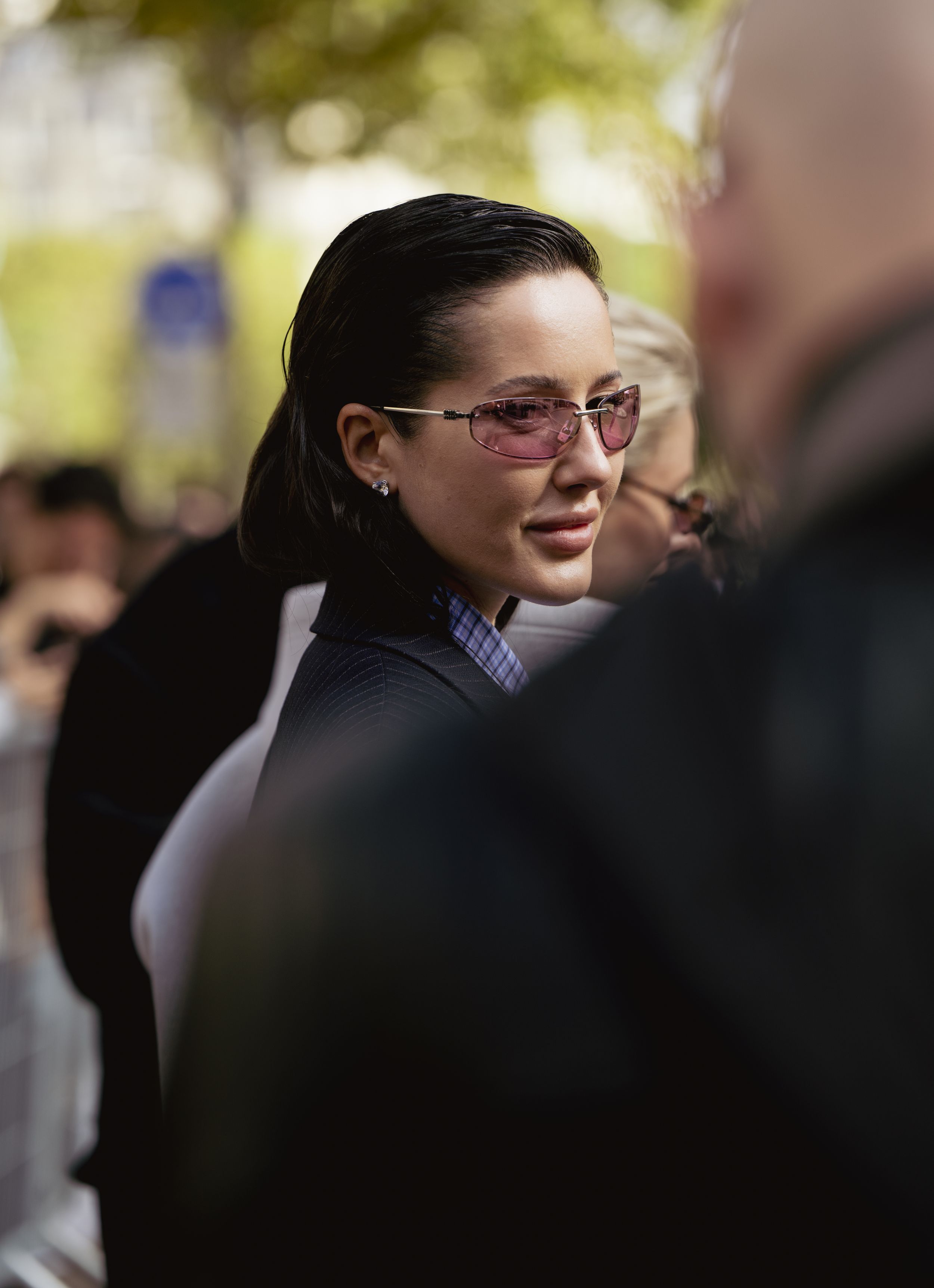Candid street style photo showing glasses and professional attire at Paris fashion week.