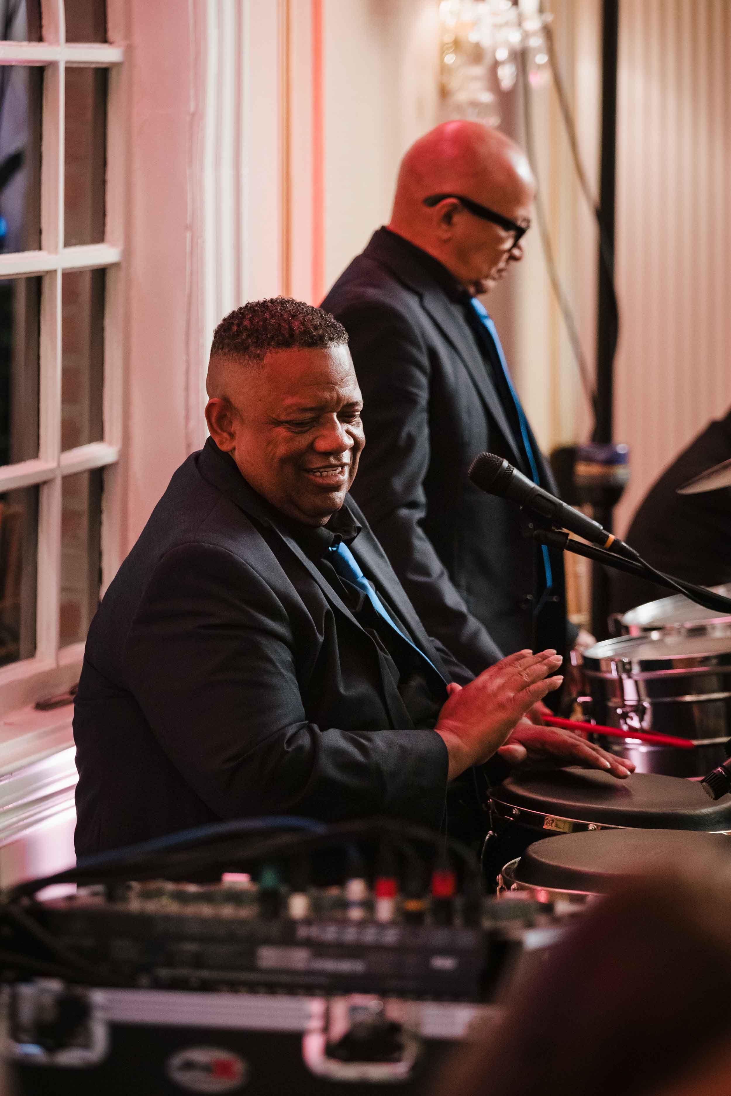 Percussionist playing congas during a live Grupo Chevere band performance at a Boston wedding reception.