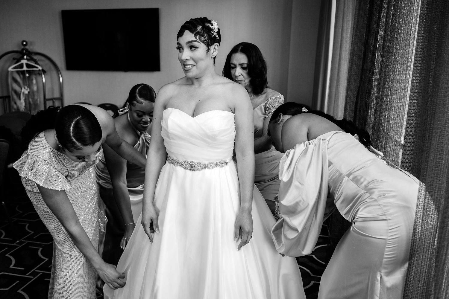 A series of black and white photos showing wedding preparation moments with people in formal white attire.