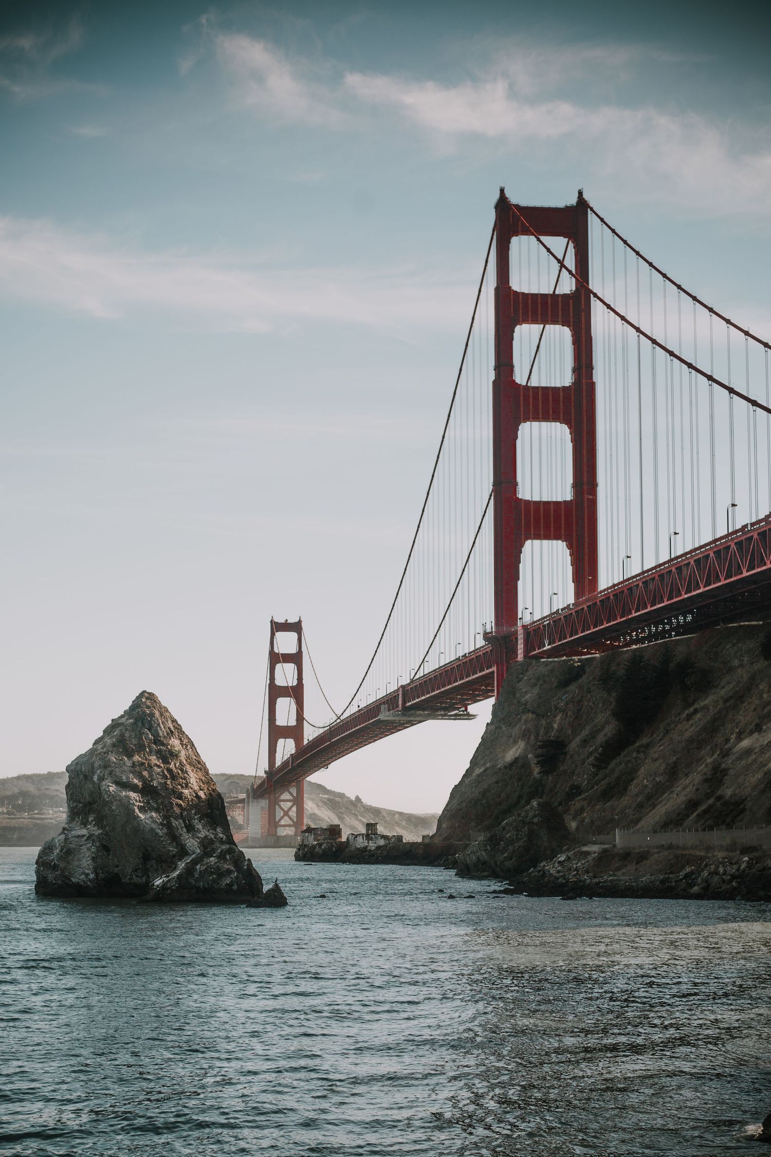 Multiple views of the iconic Golden Gate Bridge in San Francisco with rocky cliffs and blue waters of the bay.
