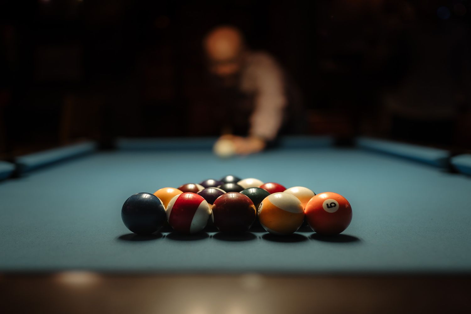 A sequence of pool balls being struck on a blue billiards table showing the progression of a trick shot.
