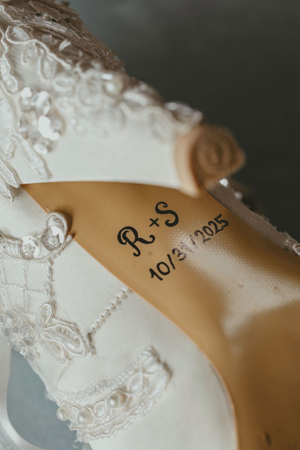 Close-up macro shot of delicate white lace details on a wedding dress with elegant embroidered patterns.
