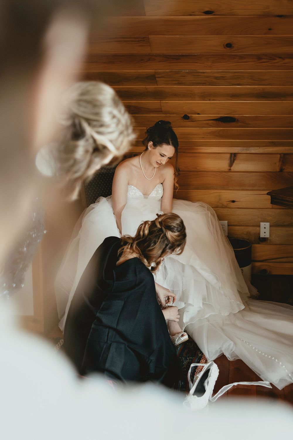 Wedding preparation sequence showing dress adjustments in a warm wood-paneled room.