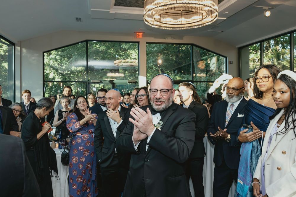 Panoramic view of wedding reception space with floor-to-ceiling windows and natural lighting.
