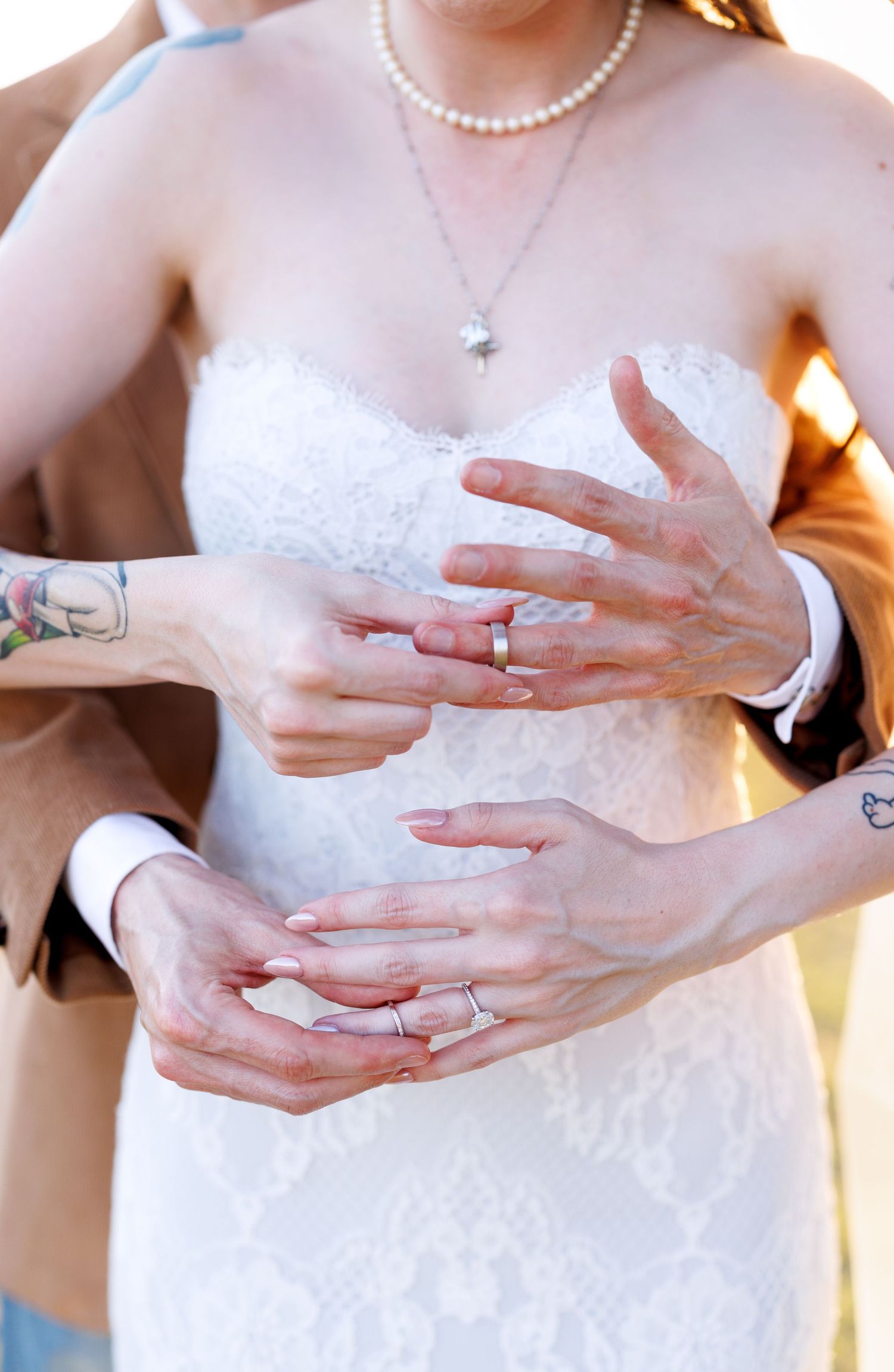 A series of close-up photos showing hands with wedding rings in white lace dress details.