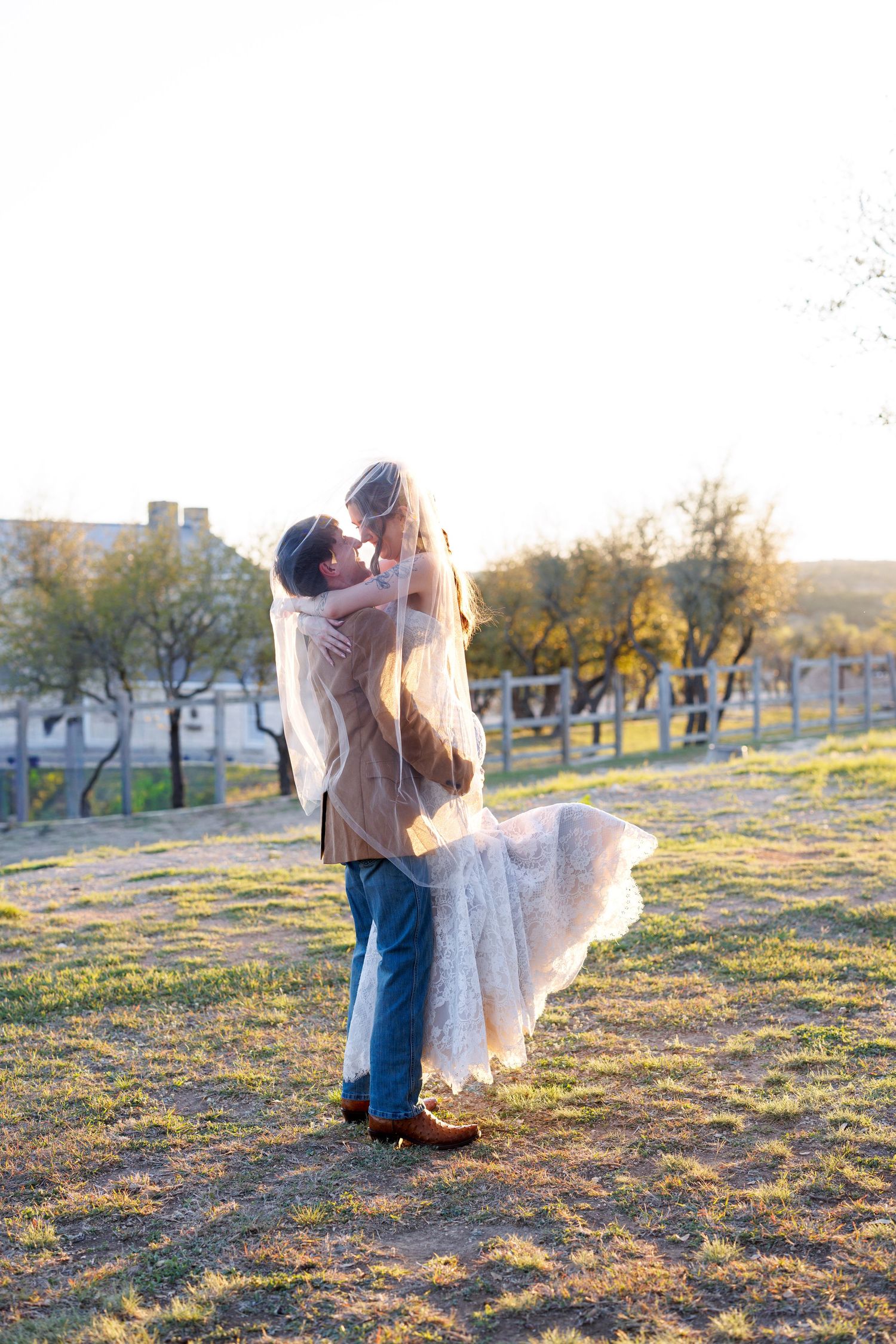 A flowing white dress twirls gracefully in the golden sunlight on a grassy hillside.