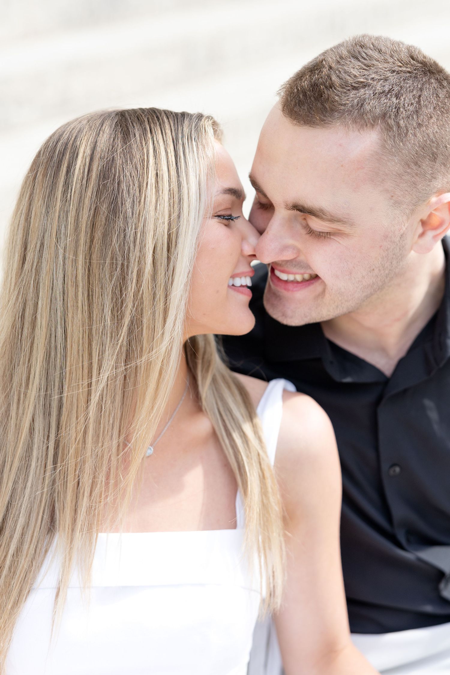 Light and airy engagement photos of a joyful couple at the Ohio Statehouse in downtown Columbus, Ohio captured by Julia and Sean Photography