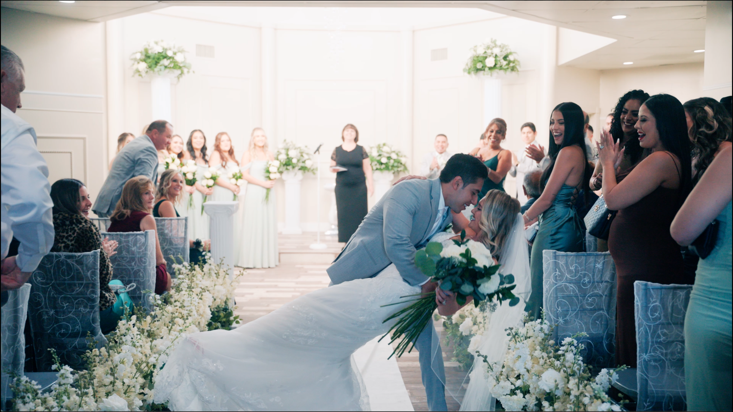 Elegant wedding ceremony moments captured in a series of soft blue-tinted photographs with decorative white floral arrangements.