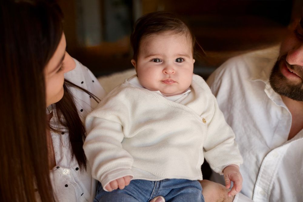 Bébé entouré de ses parents lors d’un shooting photo famille en Provence, portrait naturel et chaleureux en intérieur