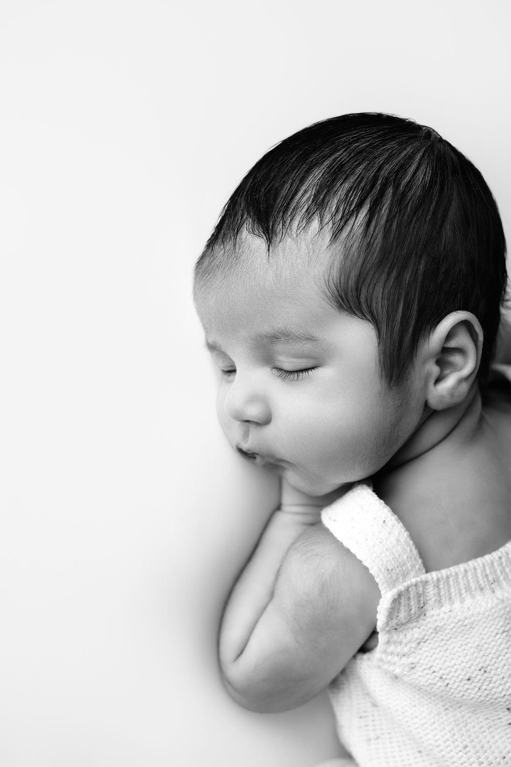A black and white series of peaceful sleeping baby photos showing different angles against a white background.