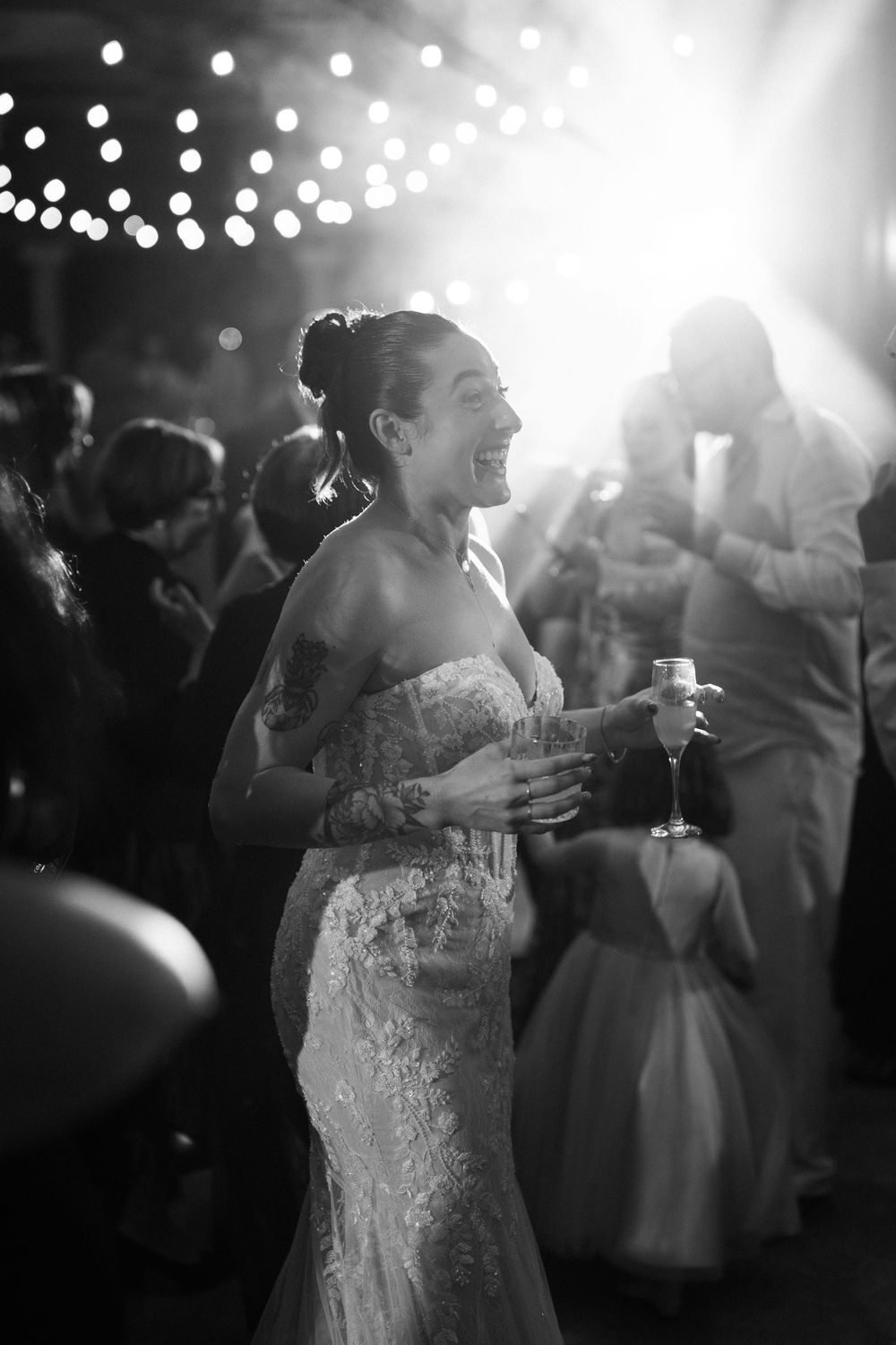 A black and white photo sequence shows a bride dancing at a wedding reception under twinkling lights.