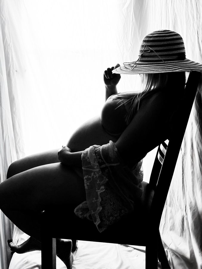 pregnant women in a beach hat sitting in a chair silhouette, black and white image