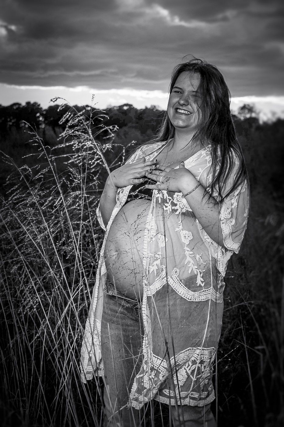 pregnant woman laughing in a field, black and white image