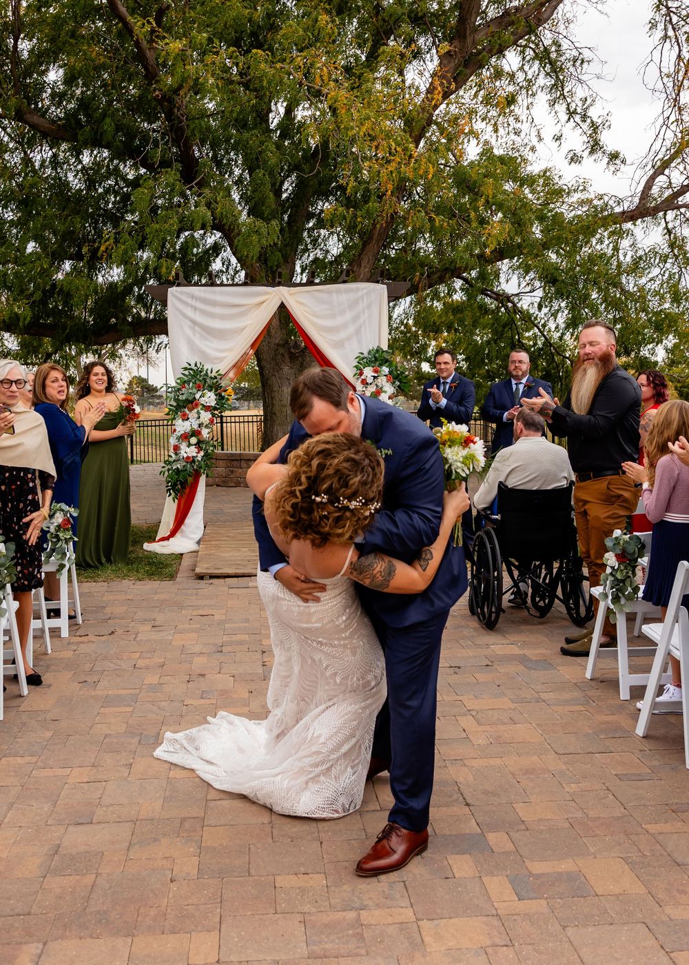 Groom dips bride for a romantic kiss at outdoor wedding ceremony at a Venue on the Ridge in Elkhorn NE