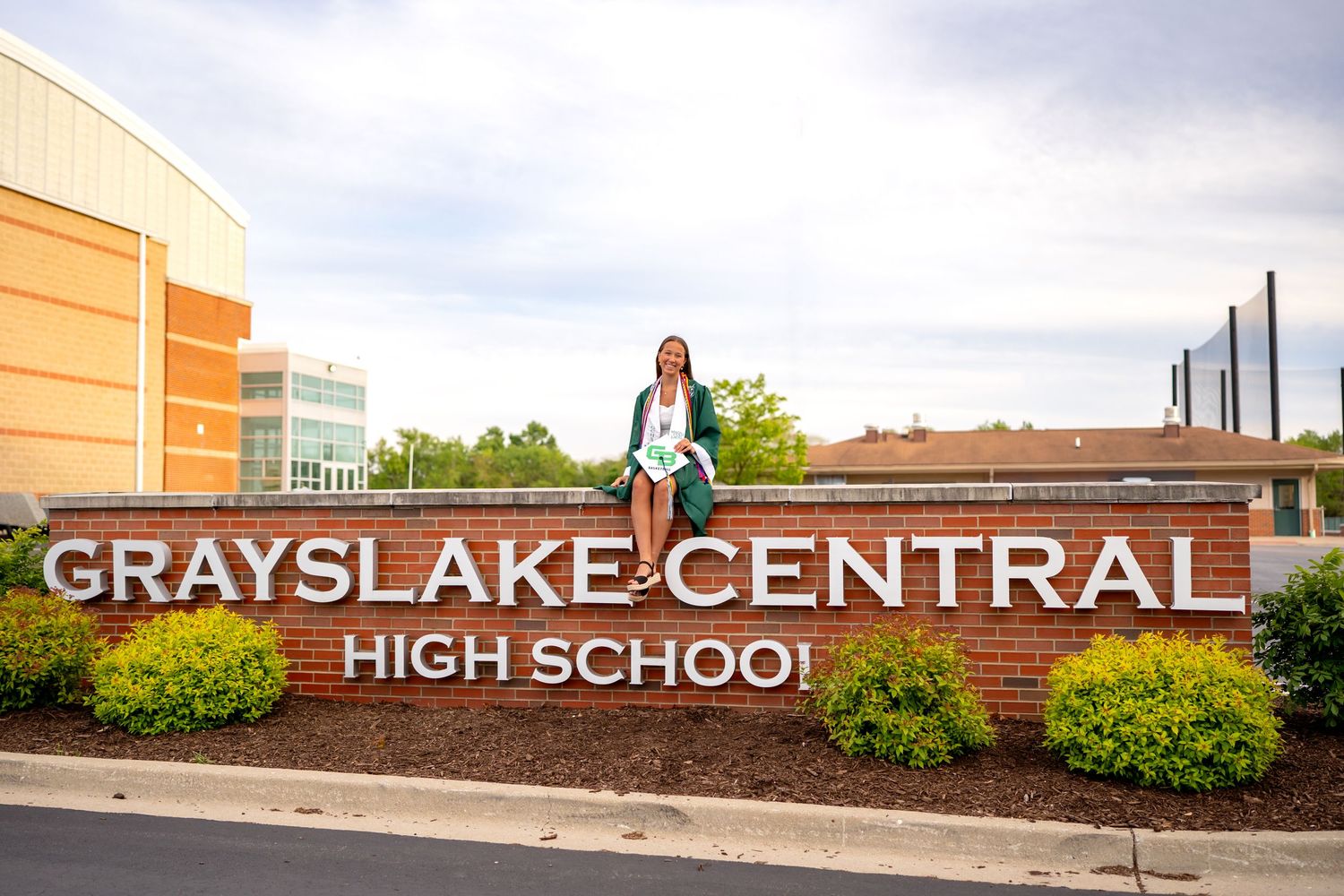 A series of exterior signs and landscaping elements showing 'Grayslake Central High School' entrance.