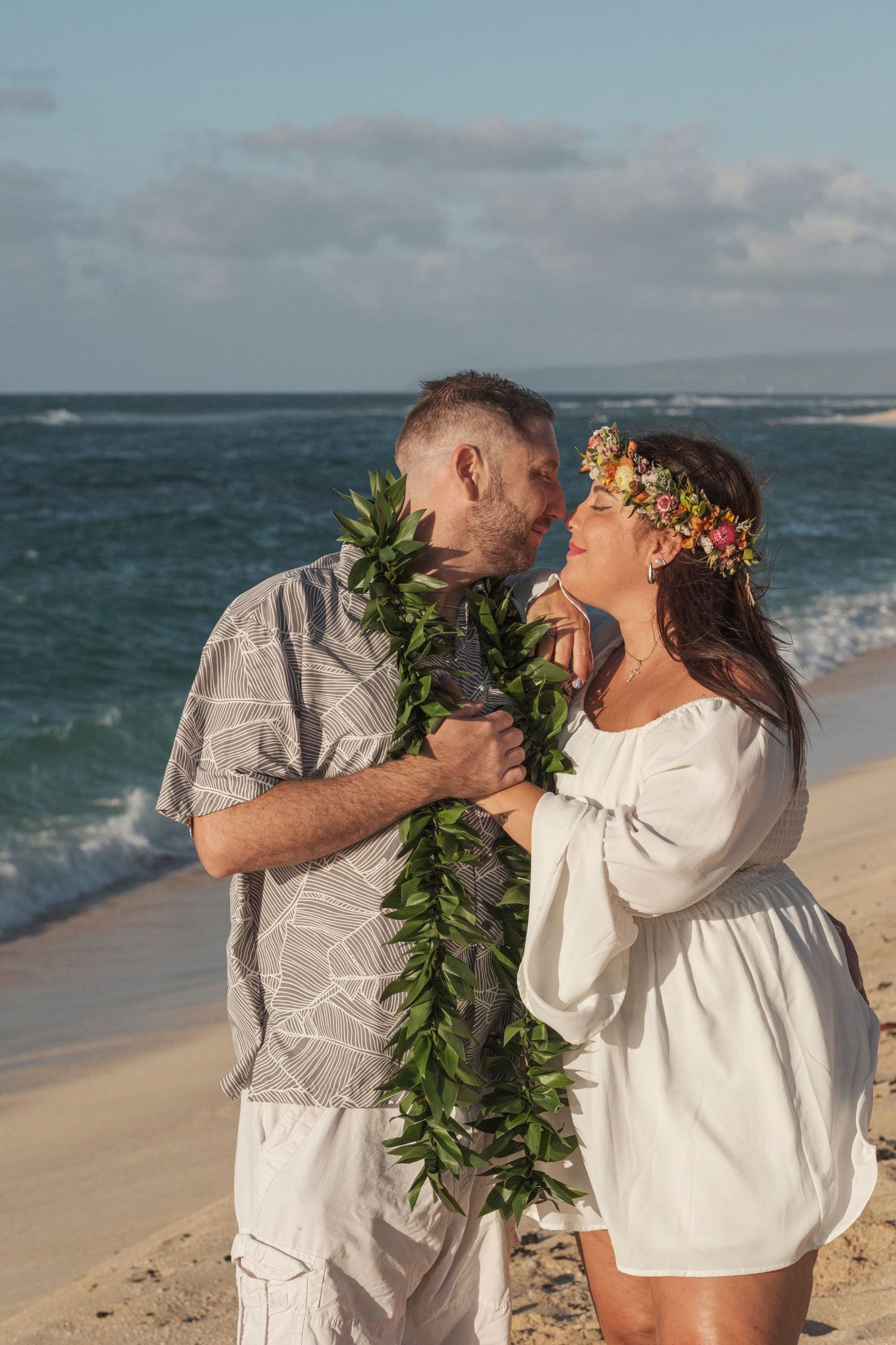 Couple sharing a romantic moment during a North Shore Oahu couples photography session at golden hour.