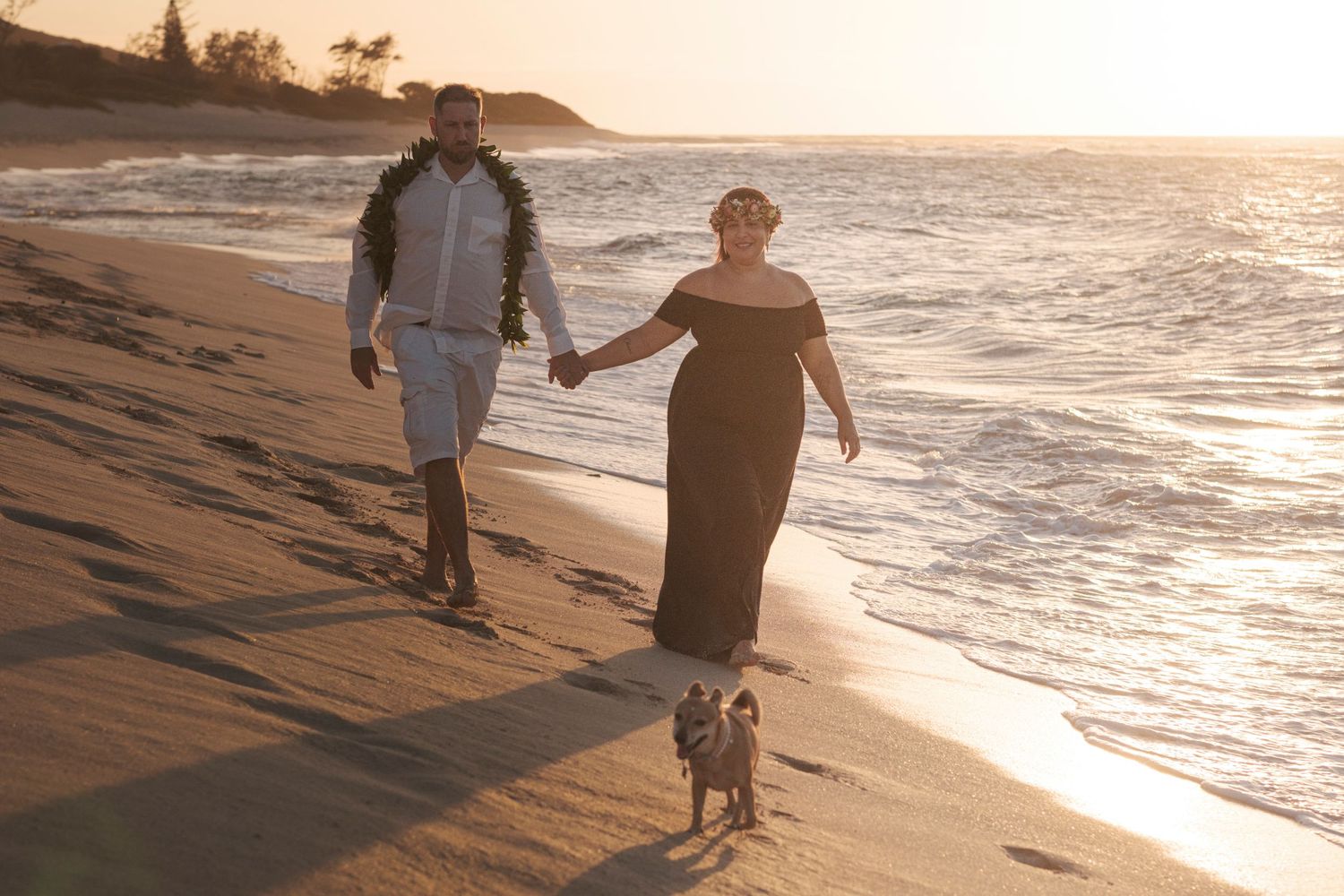 Couple walking along the shoreline during a sunset beach photography session on Oahu's North Shore.