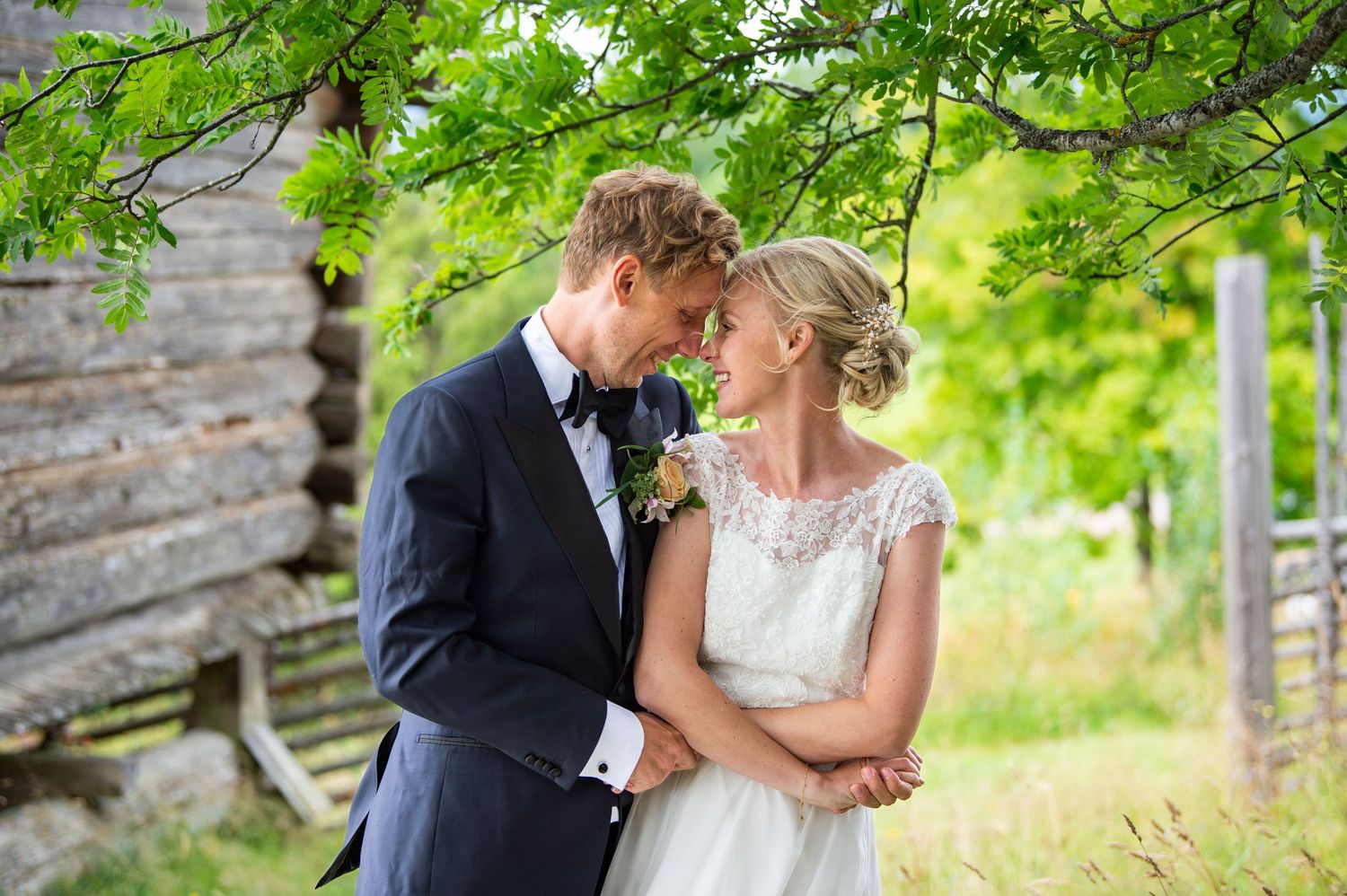 A romantic outdoor wedding photo series showing tender moments between a couple under lush green trees and rustic settings.