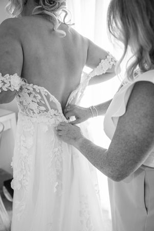 A series of black and white photos showing the back details of a wedding dress with floral appliques.
