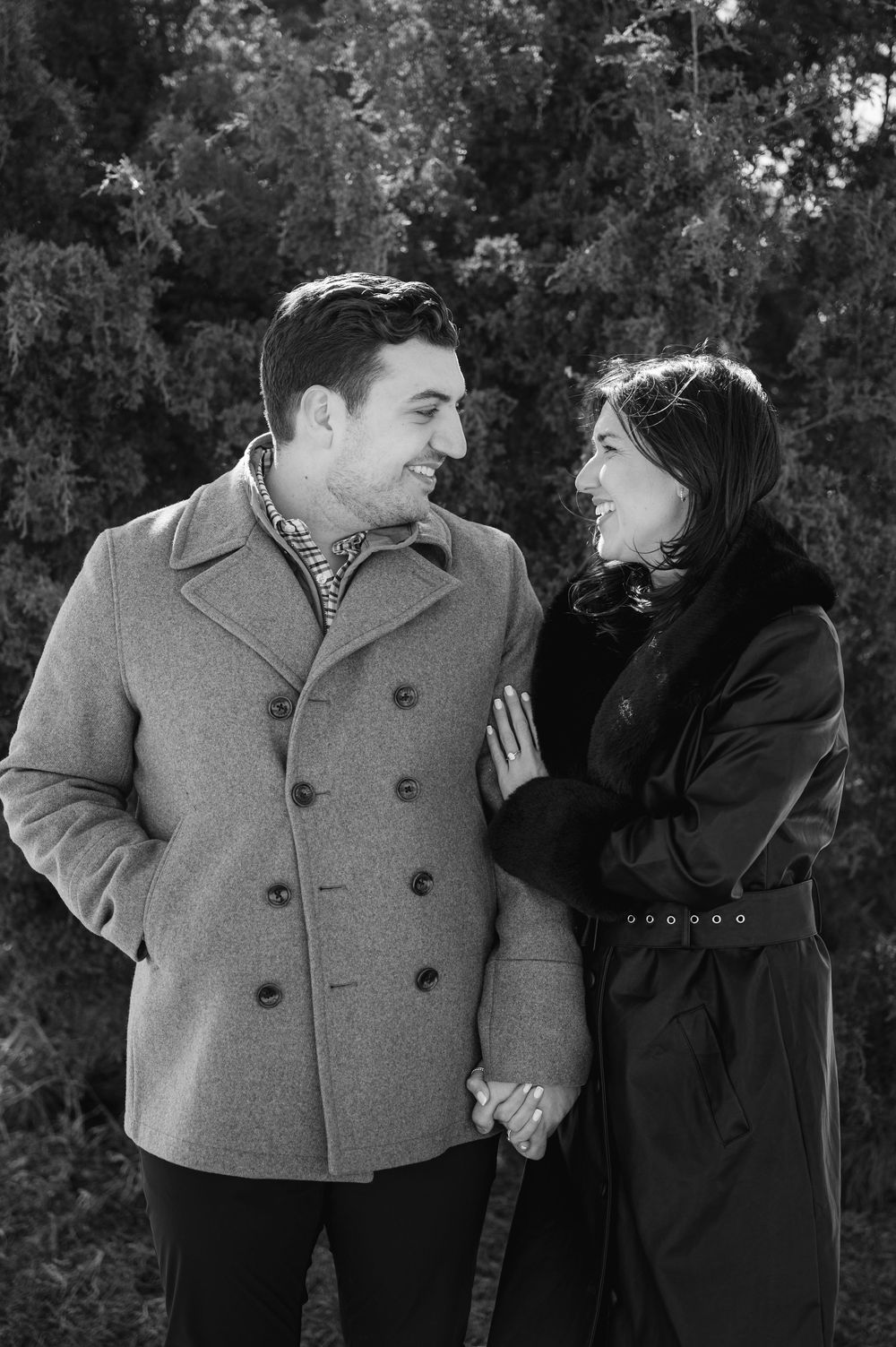 A romantic black and white photo series showing a couple in winter coats sharing intimate moments outdoors.