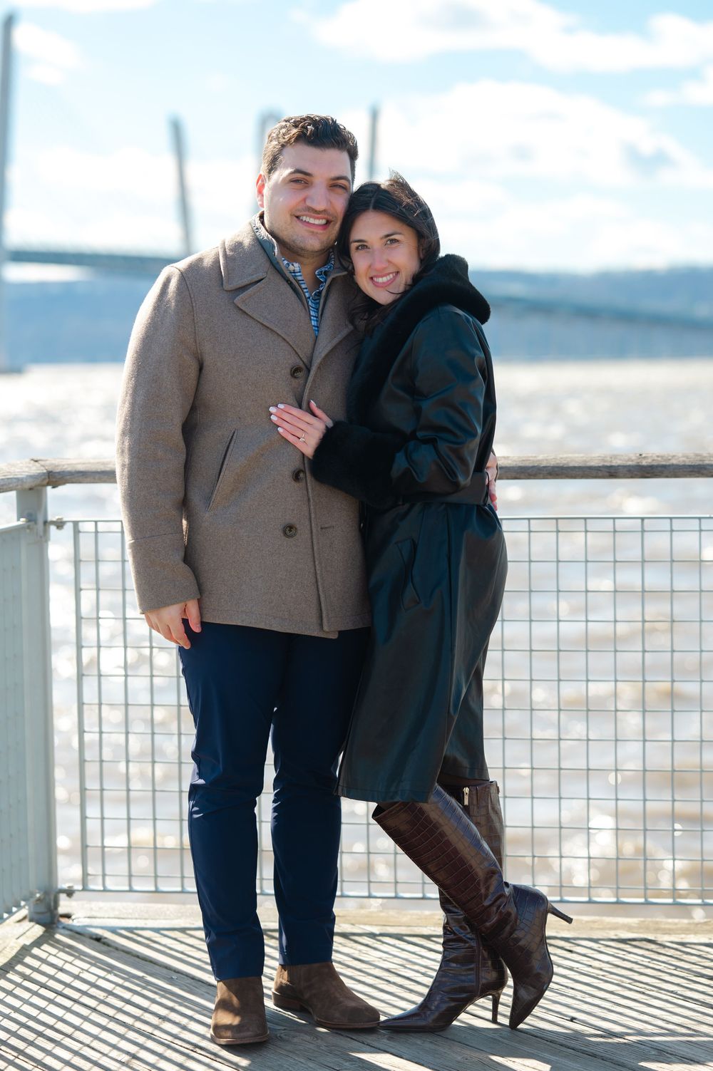 A couple poses in front of the river at a pier along the Tarrytown Scenic RiverWalk.