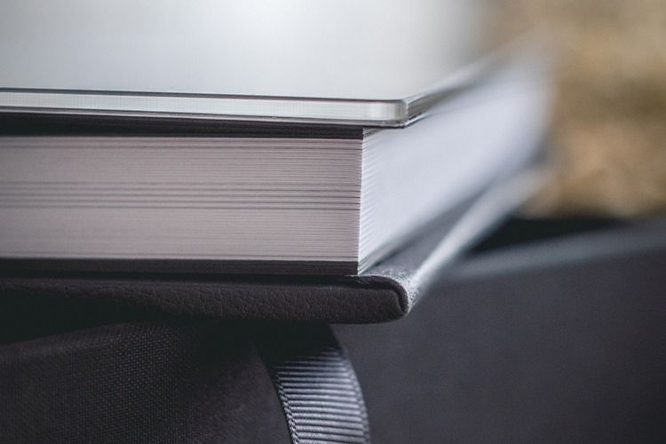 Close-up macro shots showing the edges of book pages in black and white with dramatic lighting and shadows.
